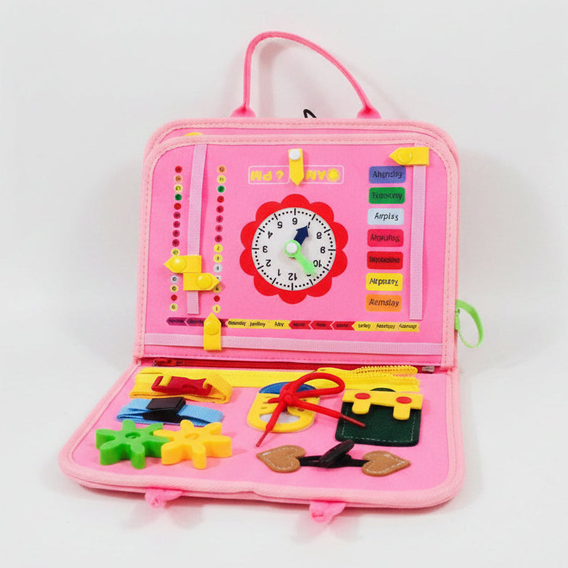 Pink educational toy with various interactive elements on a fluffy white surface.