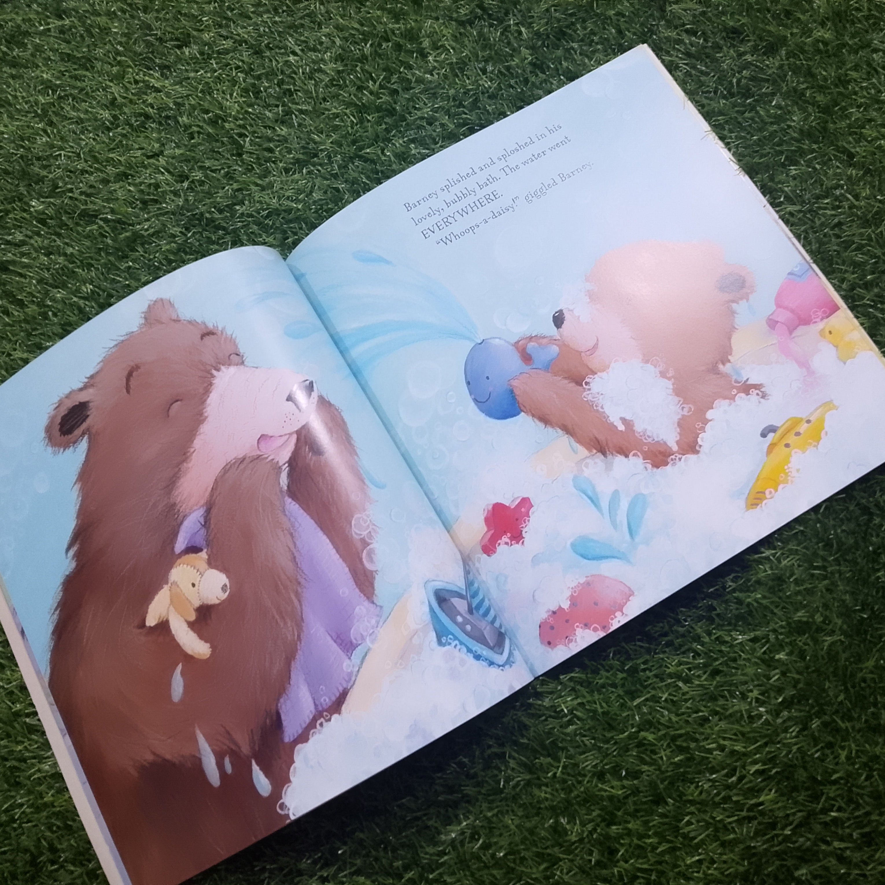 Open book with illustrations of a bear and a pig on a grassy background