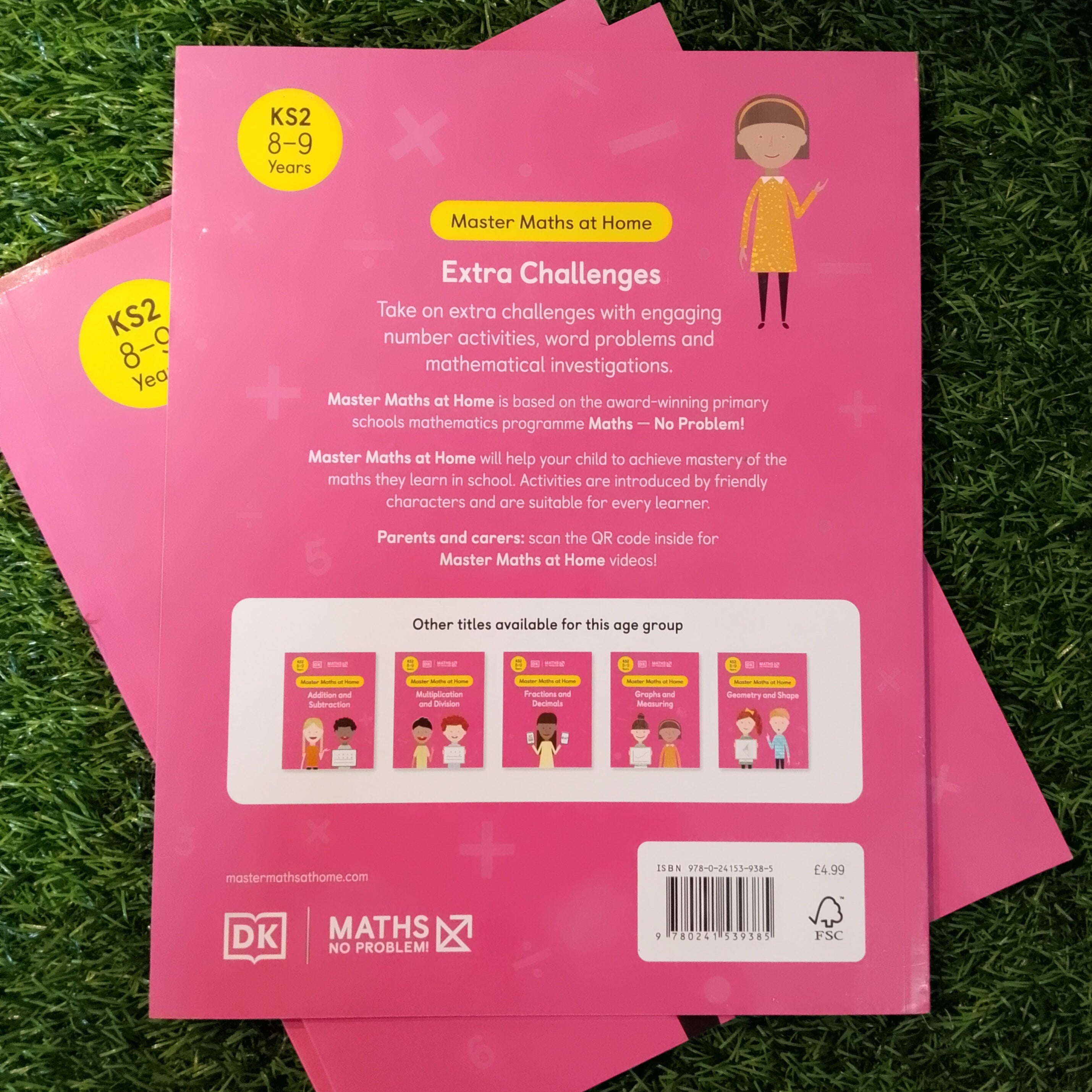 Pink educational book or worksheet on grass
