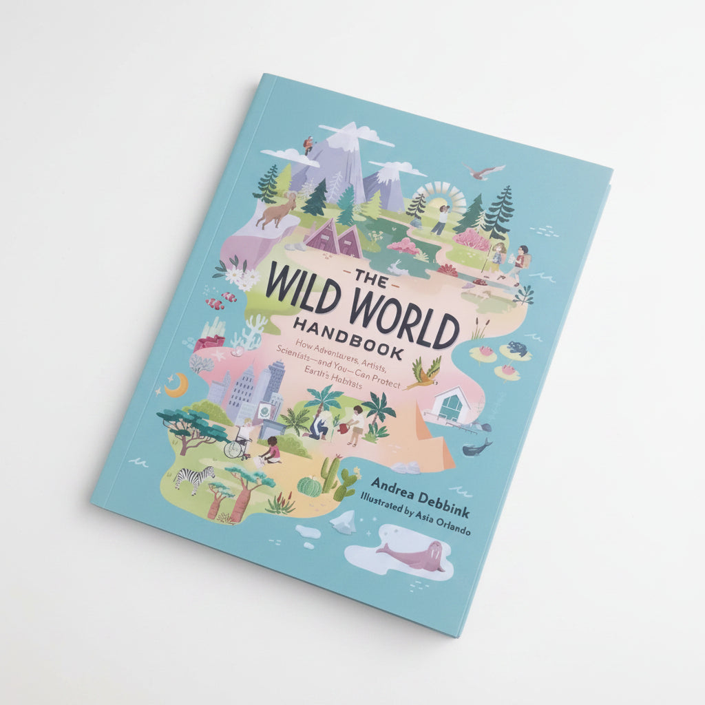 Book titled 'The Wild World Handbook' on grass