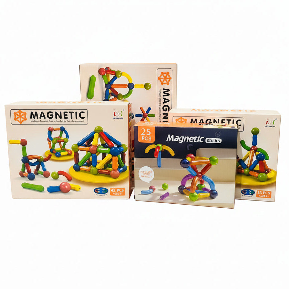 Three boxes of children's magnetic building blocks toys are displayed on a white marble table in front of a gold velvet sofa. The boxes are labeled 'MAGNETIC' and 'Magnetic clicks' with '25 PCS' and '36 PCS' markings.