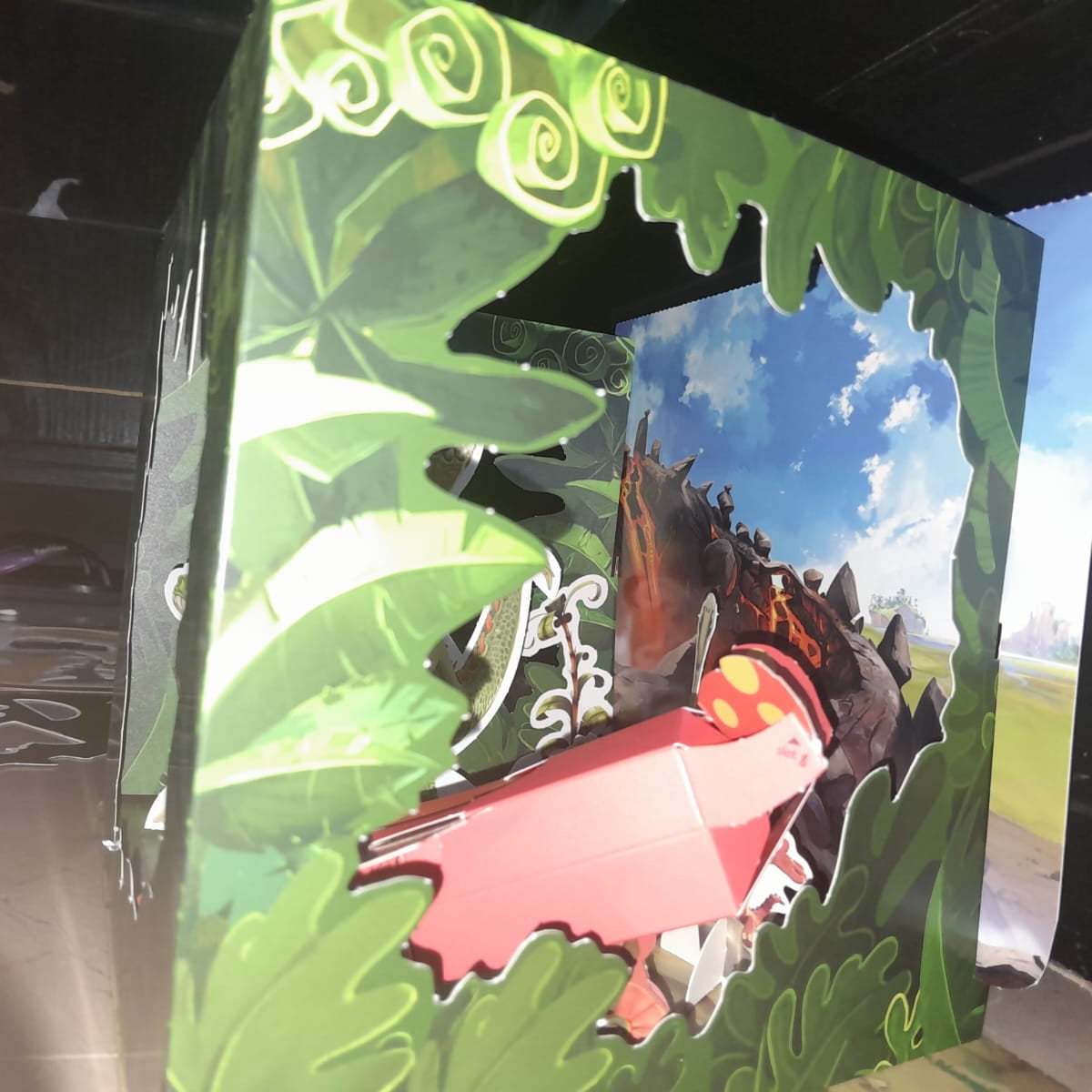 Cardboard cutout of a dragon with a scenic background